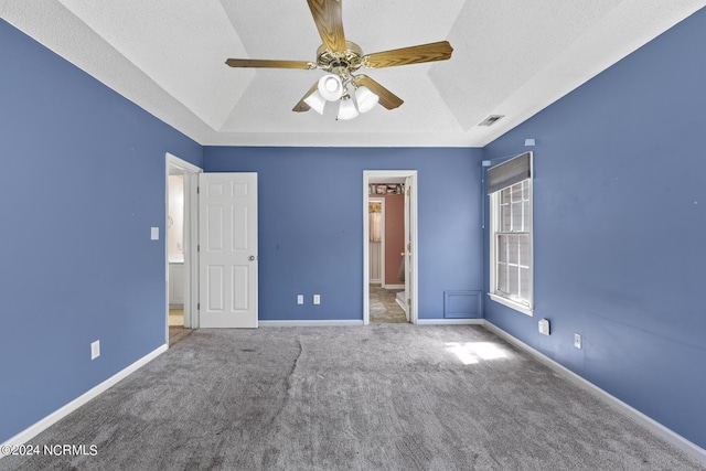 unfurnished bedroom with baseboards, visible vents, a raised ceiling, and carpet flooring