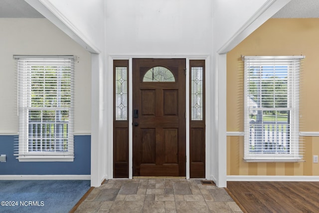 entrance foyer featuring a healthy amount of sunlight, stone finish floor, and baseboards