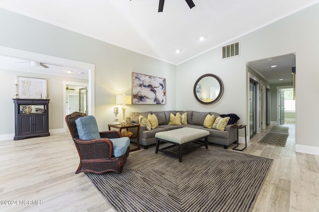 living room with light wood finished floors, visible vents, a ceiling fan, and ornamental molding