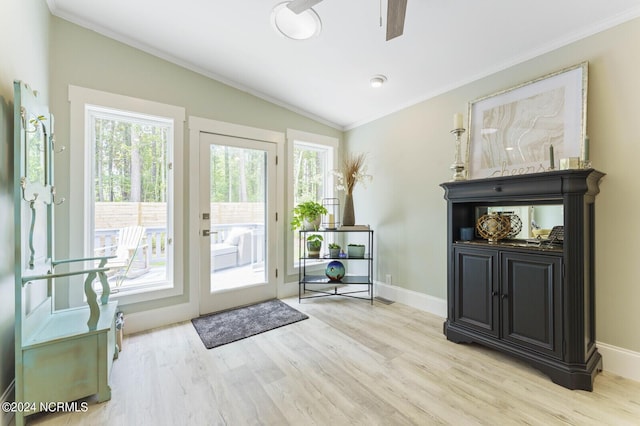 doorway with ornamental molding, baseboards, light wood-type flooring, and vaulted ceiling