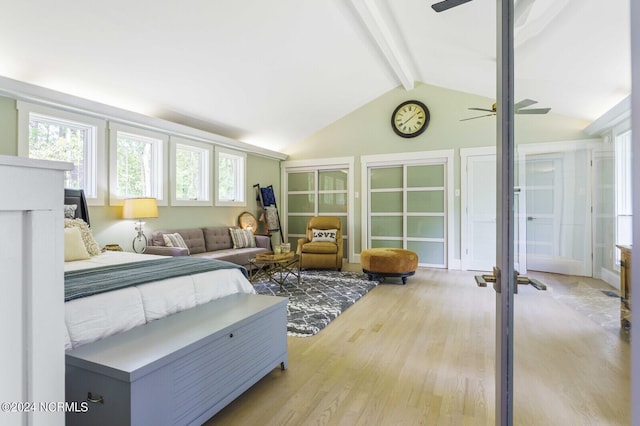 bedroom with light wood-style flooring and lofted ceiling with beams