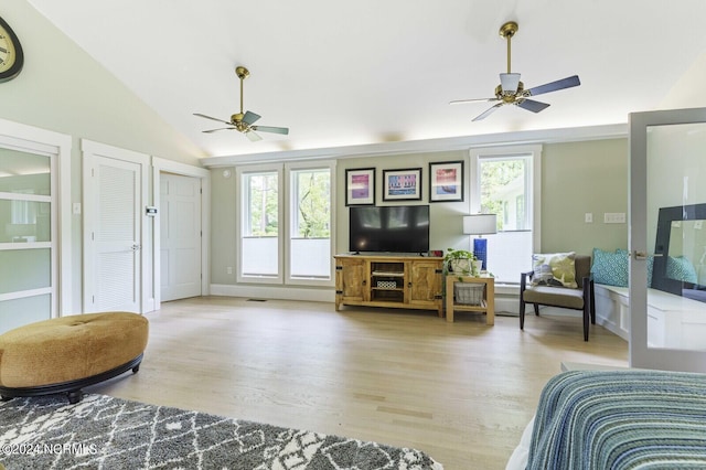 living room with wood finished floors, a ceiling fan, and vaulted ceiling
