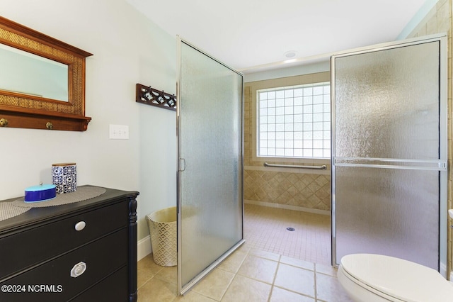 full bath with toilet, a shower stall, and tile patterned flooring