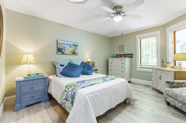 bedroom featuring baseboards, light wood-type flooring, and a ceiling fan