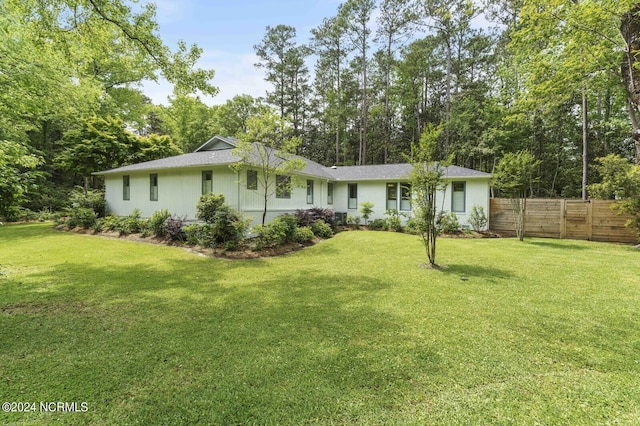 view of front of home with fence and a front lawn