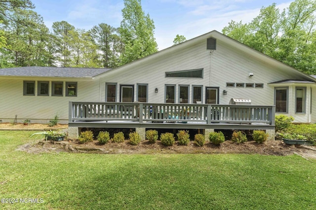 back of property featuring a yard and a wooden deck
