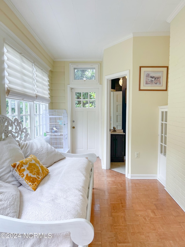 bedroom with light parquet floors, multiple windows, ensuite bathroom, and ornamental molding