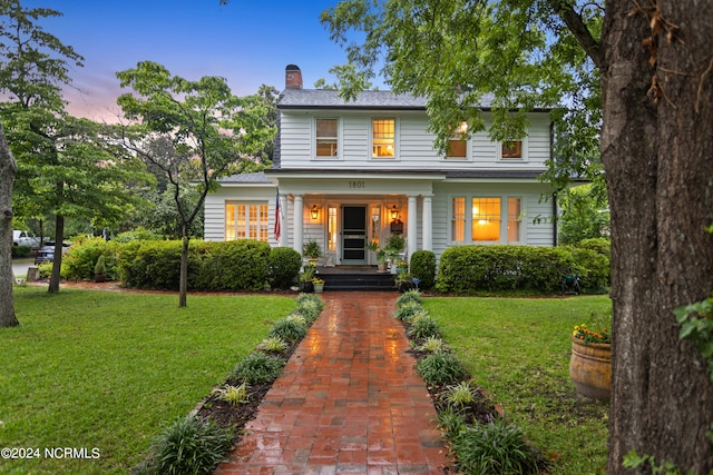 view of front of property featuring a porch and a lawn