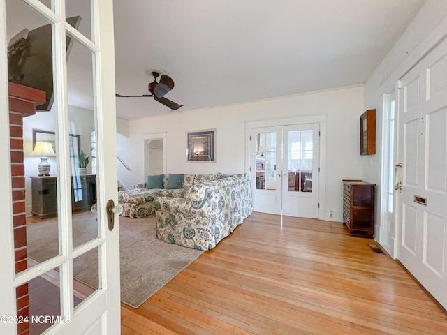 living room with ceiling fan, light hardwood / wood-style floors, and french doors