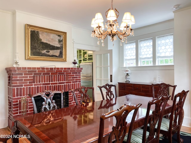 dining space with a chandelier, wood-type flooring, and crown molding