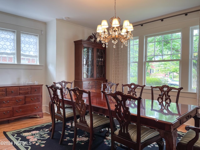 dining room featuring a notable chandelier, hardwood / wood-style flooring, and ornamental molding