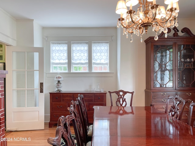 dining space with light wood-type flooring and a chandelier