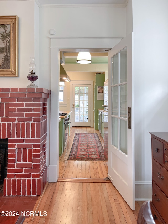 hall with ornamental molding and hardwood / wood-style floors