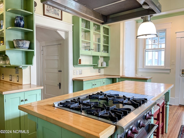 kitchen with green cabinetry, butcher block counters, and light hardwood / wood-style flooring