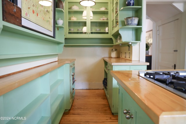 kitchen with light hardwood / wood-style floors, green cabinets, and butcher block countertops