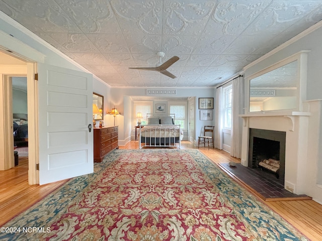 bedroom featuring wood-type flooring, ceiling fan, and crown molding