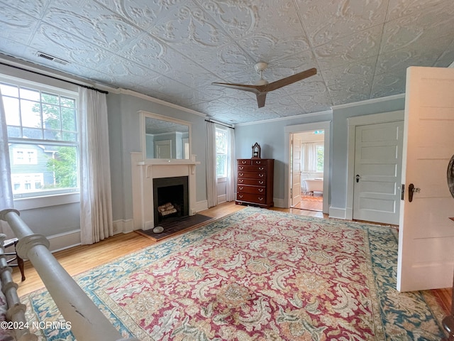 living room featuring a wealth of natural light, ceiling fan, crown molding, and hardwood / wood-style flooring