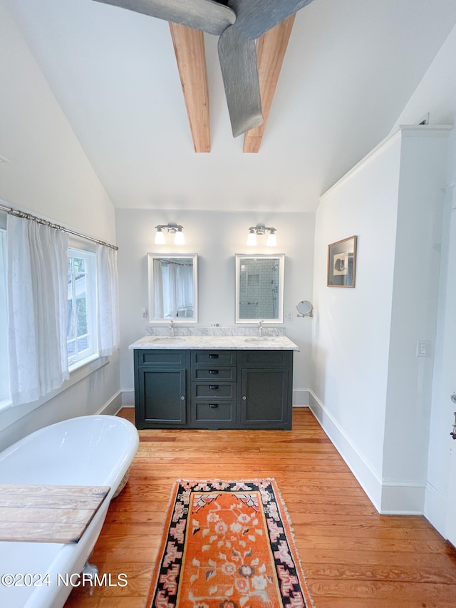 bathroom with dual vanity, a washtub, lofted ceiling with beams, and hardwood / wood-style floors