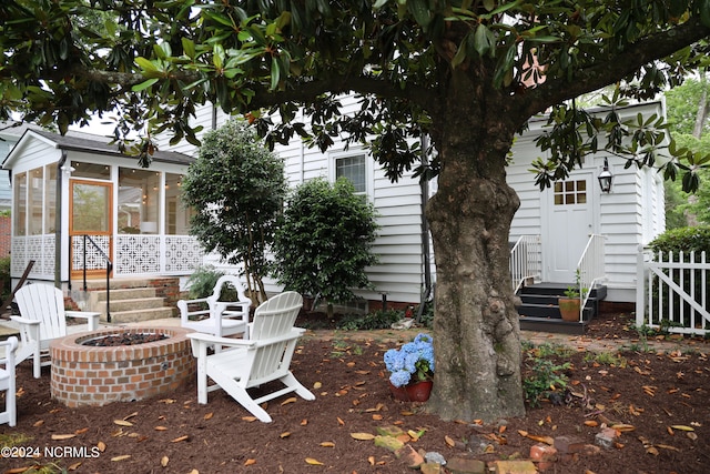 view of patio / terrace with a sunroom and a fire pit