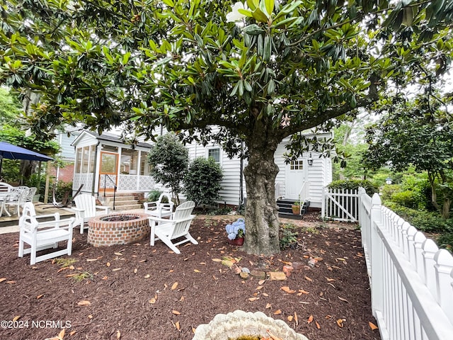 view of yard featuring an outdoor fire pit and a sunroom