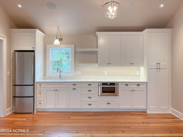 kitchen with white cabinetry, light wood-type flooring, and stainless steel appliances