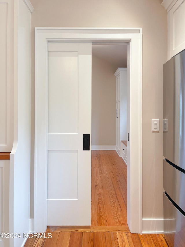 corridor with light hardwood / wood-style flooring