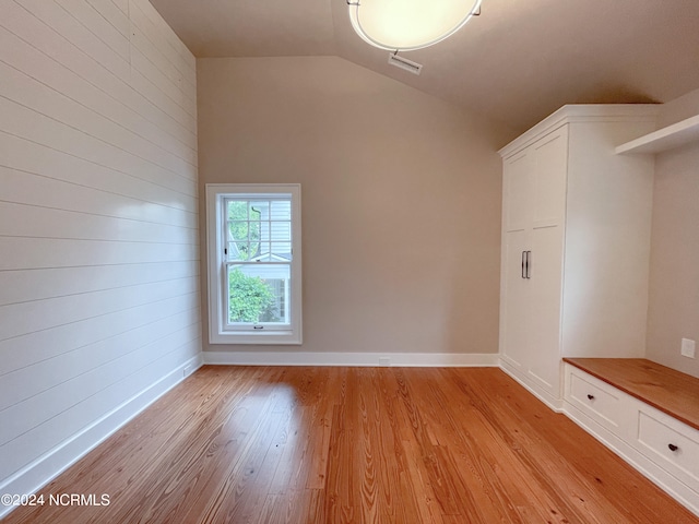 unfurnished room featuring light hardwood / wood-style flooring and vaulted ceiling