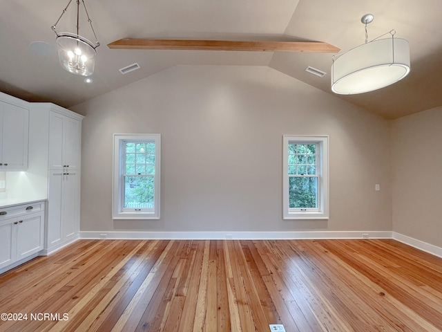 unfurnished room featuring lofted ceiling with beams and light wood-type flooring