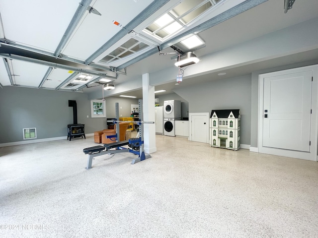 garage featuring white fridge, stacked washer / dryer, and a wood stove