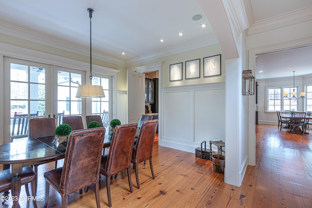 dining room with an inviting chandelier, hardwood / wood-style floors, and crown molding