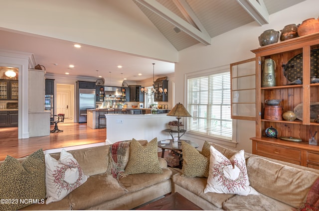 living room with high vaulted ceiling, beamed ceiling, hardwood / wood-style floors, and a chandelier