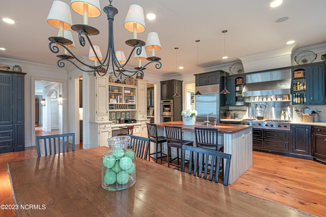 dining space featuring ornamental molding, light wood-type flooring, and a chandelier