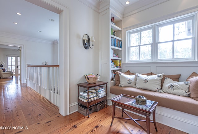 living room featuring built in features, crown molding, and hardwood / wood-style flooring