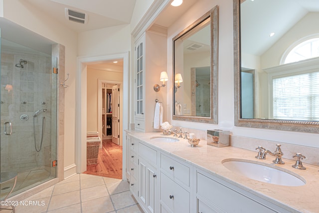 bathroom featuring vanity with extensive cabinet space, tile floors, a shower with door, double sink, and lofted ceiling