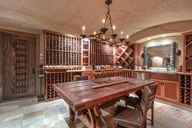 wine cellar with a notable chandelier, sink, and light tile flooring