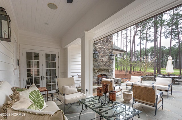 view of patio featuring an outdoor living space with a fireplace and french doors