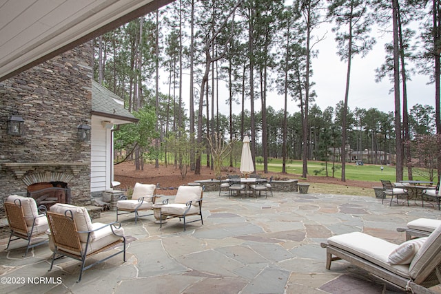 view of terrace with an outdoor stone fireplace