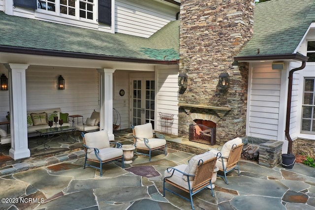 view of terrace with an outdoor living space with a fireplace