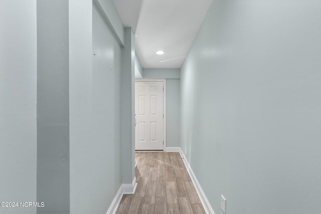 hallway with light wood-style flooring and baseboards