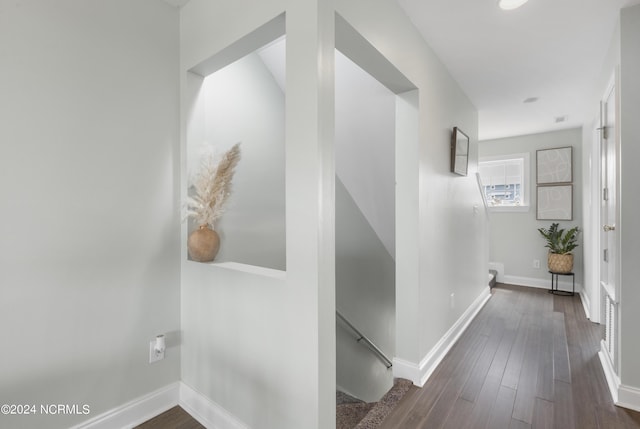 corridor with dark wood-style floors and baseboards