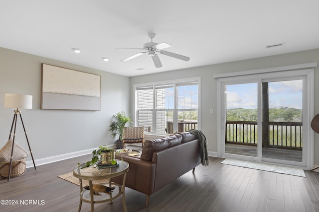 living room featuring baseboards, visible vents, ceiling fan, and wood finished floors