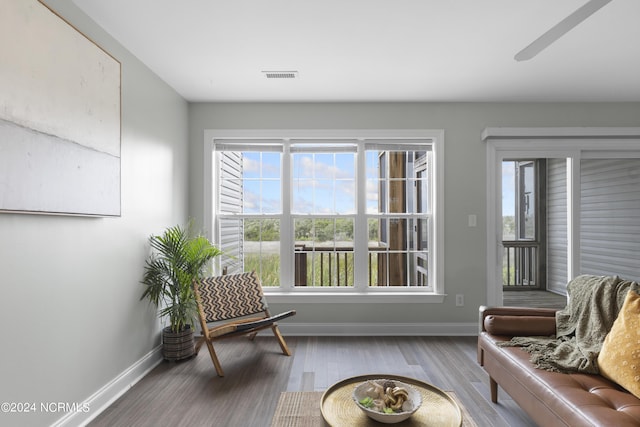 living area with baseboards, visible vents, and wood finished floors