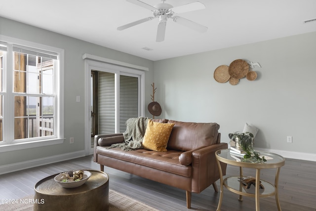 living room with ceiling fan, wood finished floors, visible vents, and baseboards