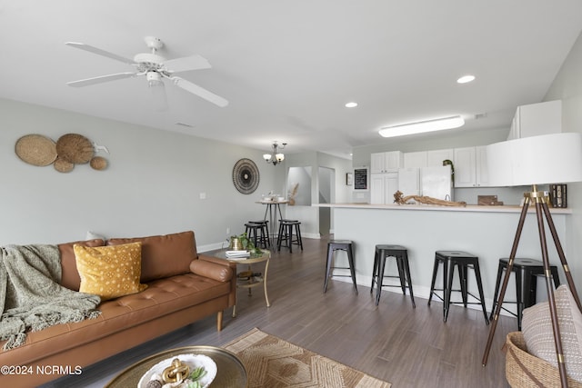 living area featuring baseboards, dark wood finished floors, a ceiling fan, and recessed lighting