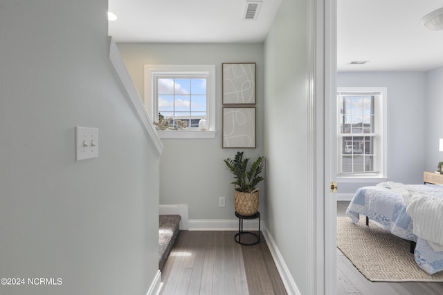 bedroom featuring baseboards, visible vents, and wood finished floors