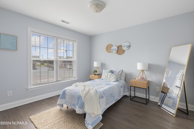 bedroom featuring dark wood-style flooring, visible vents, and baseboards