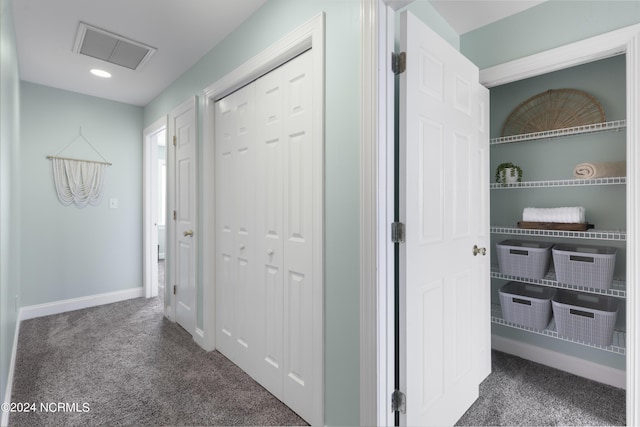 hall featuring carpet, visible vents, and baseboards