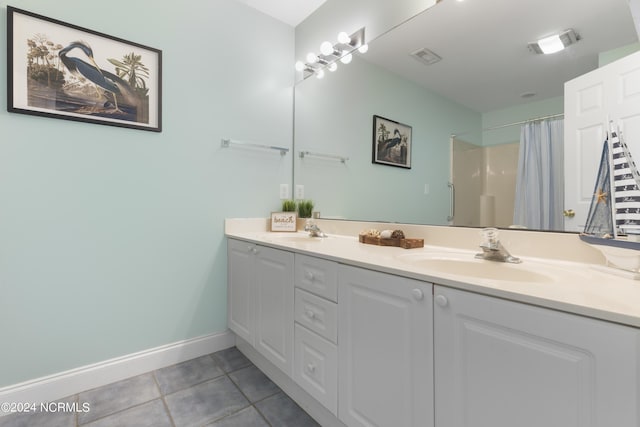 bathroom featuring baseboards, double vanity, a sink, and tile patterned floors