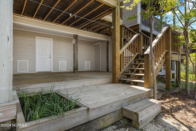 wooden terrace with a carport, visible vents, and stairway