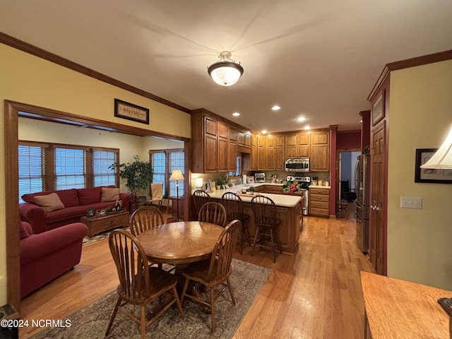 dining room featuring light wood-style floors, recessed lighting, and crown molding